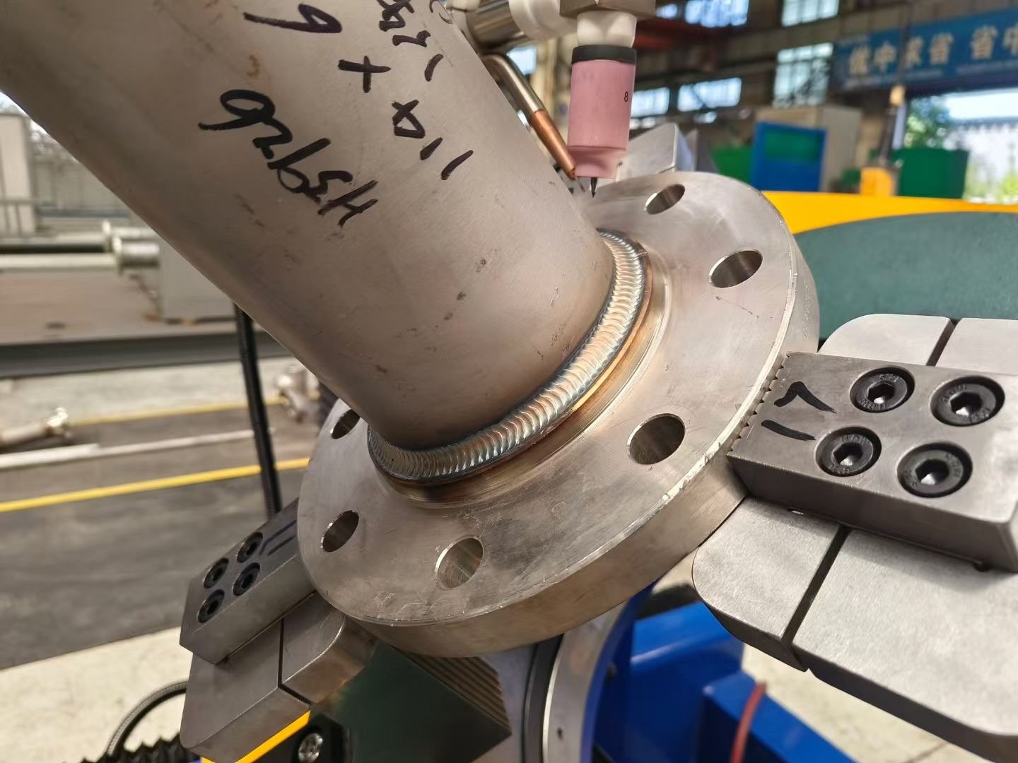 Automatic TIG welding system creating a flange pipe connection weld for industrial piping applications