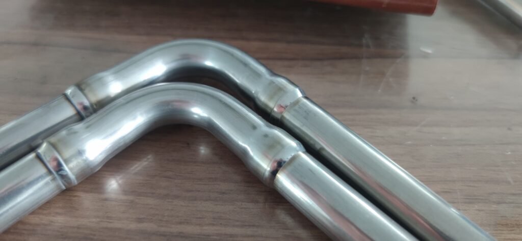 Closed orbital TIG welding head for automatic welding of a bent tube joint
