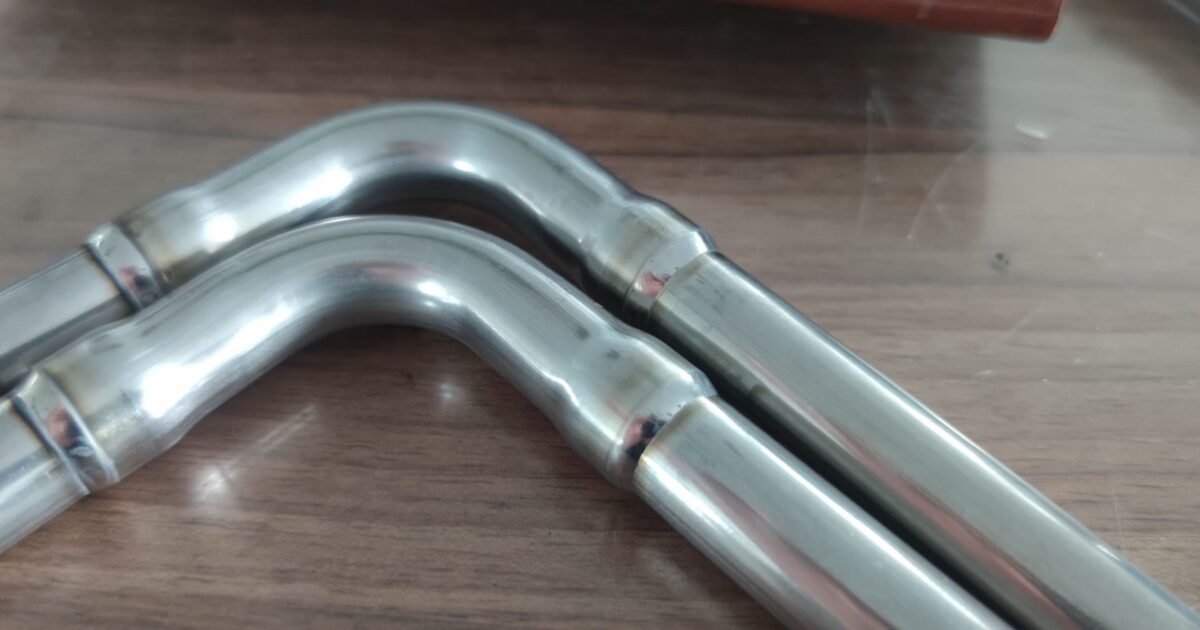 Closed orbital TIG welding head for automatic welding of a bent tube joint