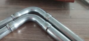 Closed orbital TIG welding head for automatic welding of a bent tube joint
