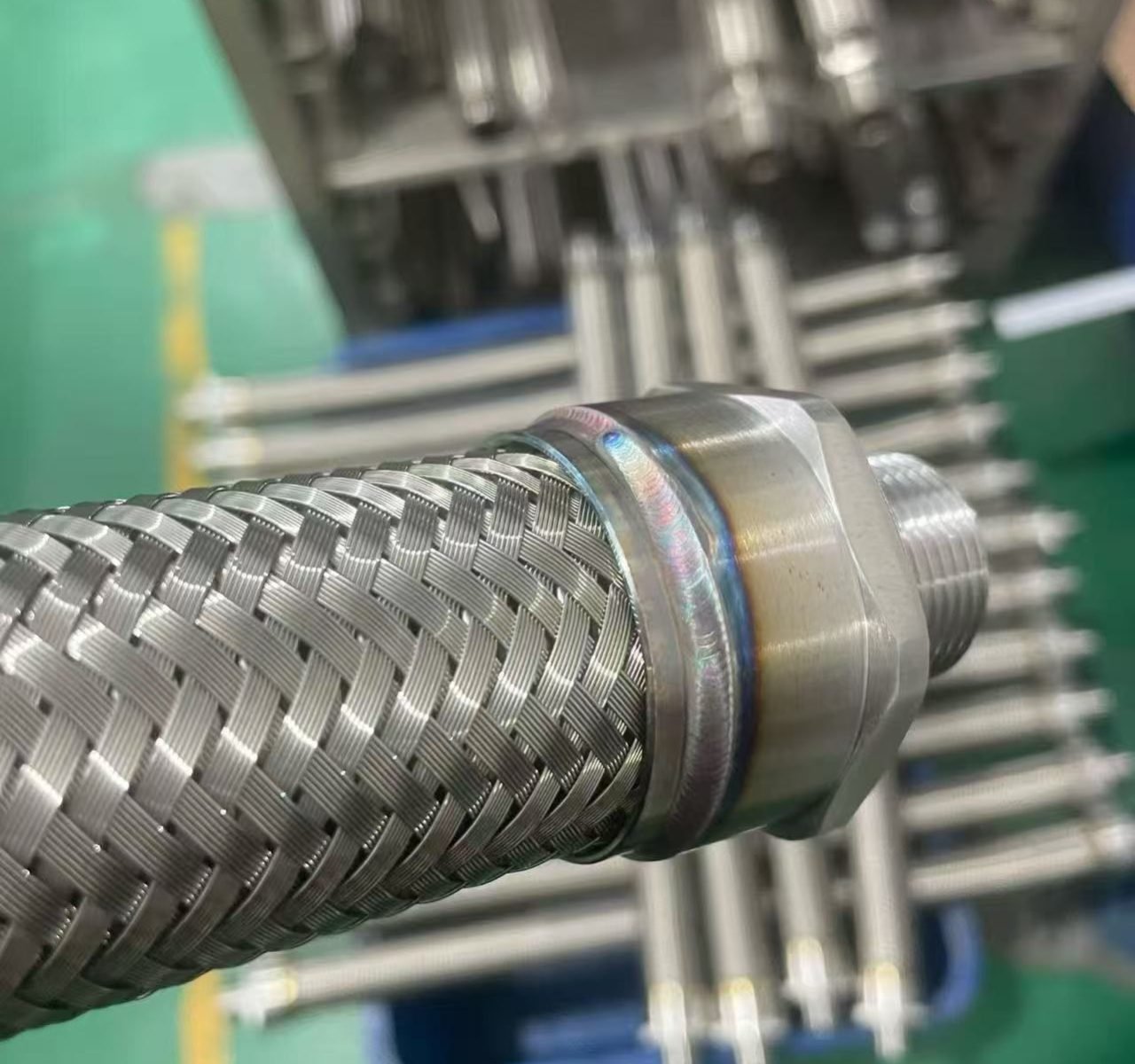 TIG-welded braided corrugated stainless steel hose fitting showing the completed circumferential weld joint